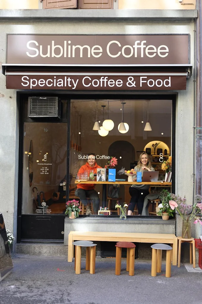 La devanture brune de Sublime Coffee, « Specialty Coffee & Food », rue Leschot 10 à Genève, avec son banc et ses tabourets en bois.